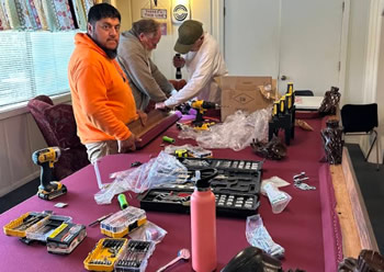 Technician inspecting worn pool table felt in a San Jose living room
